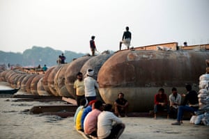 Allahabad, India. Labourers rest during construction of a temporary floating bridge over the Ganges for the Magh Mela