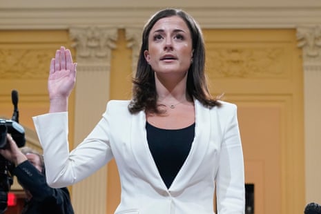 A younger woman raises her hand while being sworn in before testifying at a hearing