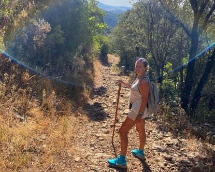 Elaine Kingett hiking in southern Spain on a rock path surrounded by trees.