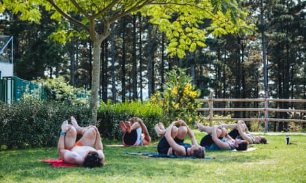 An outdoor yoga class, people lying on their backs