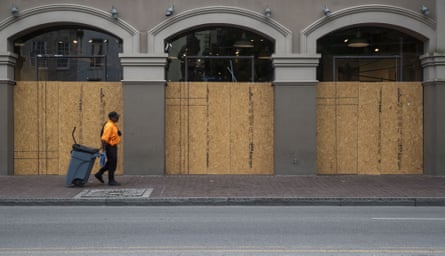 A worker walks past a boarded up store in New Orleans, Louisiana, U.S., on Wednesday, April 8, 2020. On Wednesday, Louisiana reported 17,030 Covid-19 cases and 652 deaths, according to the Louisiana Department of Health.