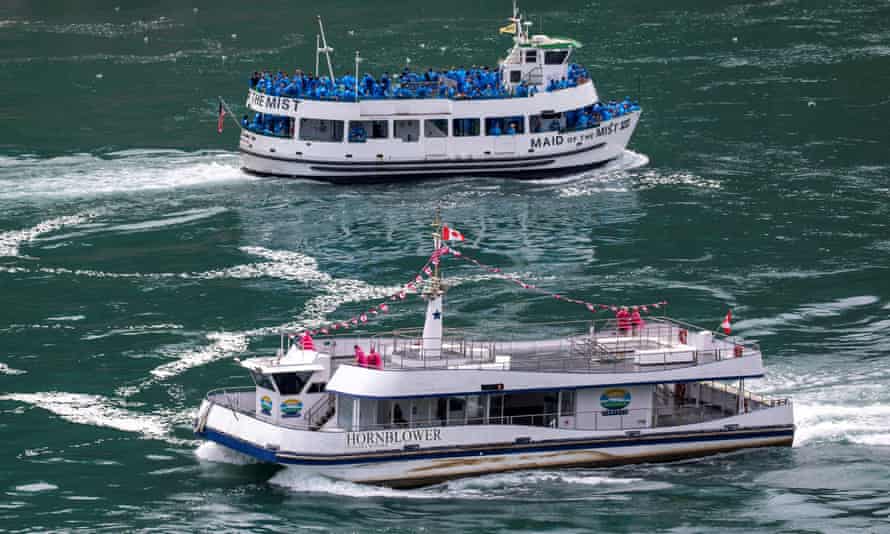 American tourist boat glides past a Canadian vessel limited to just six passengers in Niagara Falls
American tourist boat Maid Of The Mist, limited to 50 % occupancy under New York state’s rules amid the spread of the coronavirus disease, on Tuesday in Niagara Falls, Ontario, Canada.