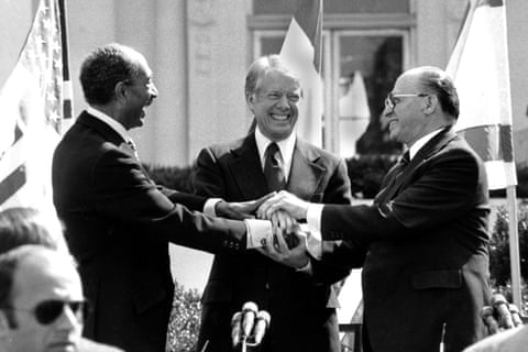 The Egyptian president, Anwar Sadat, left; US president, Jimmy Carter, center; and Israeli prime minister, Menachem Begin clasp hands on the north lawn of the White House after signing the peace treaty between Egypt and Israel, on 26 March 1979. Photograph: Bob Daugherty/AP