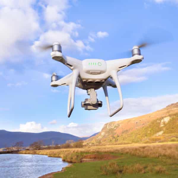 A drone flying over hills and a lake