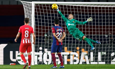 Barcelona's Iñaki Peña saves a free-kick from Atletico's Memphis Depay by jumping to his right and stretching out his right arm.