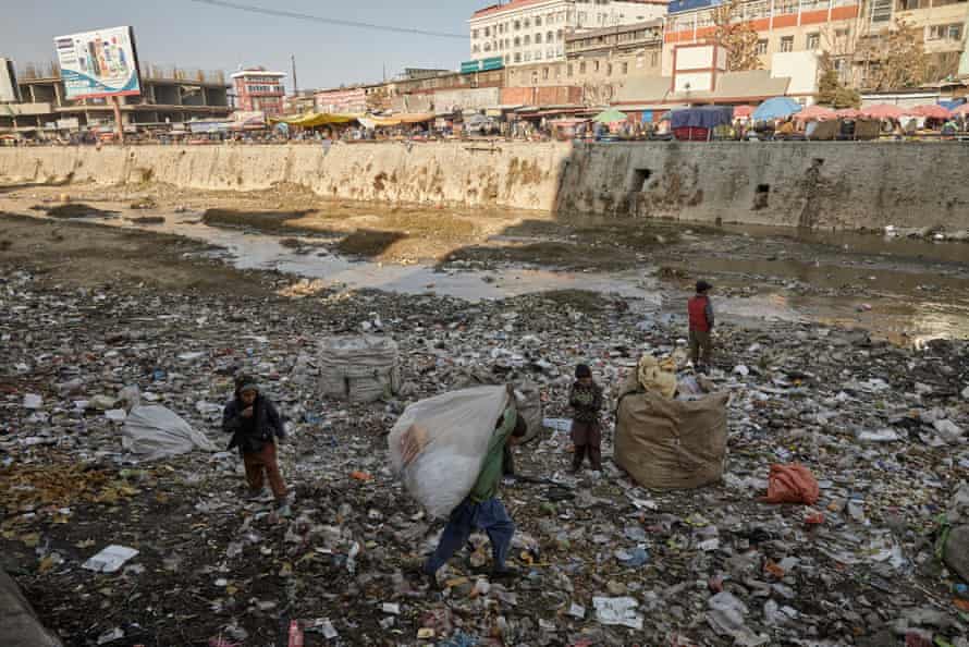 Children collect plastic for sale from the banks of the Kabul River.