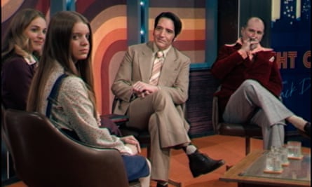 film still of four people sitting on seats in a studio