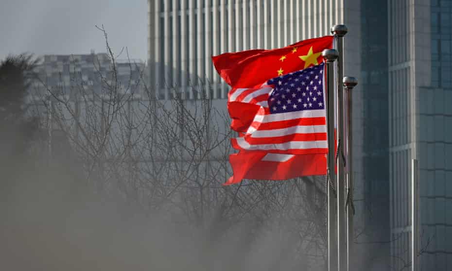 Chinese and US national flags flutter at the entrance of a company office building in Beijing