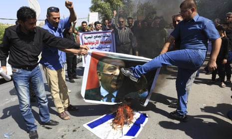 Iraqi protesters burn a poster depicting Turkish president Recep Tayyip Erdoğan, along with Israeli flags