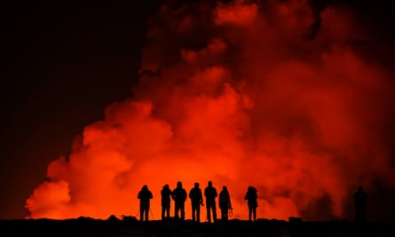 Silhouettes of people from behind watching the eruption