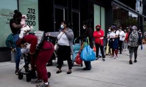 People wait in line to get care packages with food donations from the Food Bank for New York City in Brooklyn on 15 May.