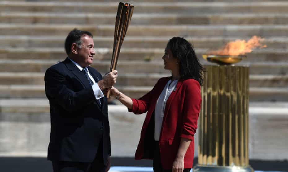 The Greek sports minister, Spyros Capralos, handed the Olympic torch over to the former Japanese swimmer Imoto Naoko during a ceremony in Athens on Thursday despite the coronavirus crisis