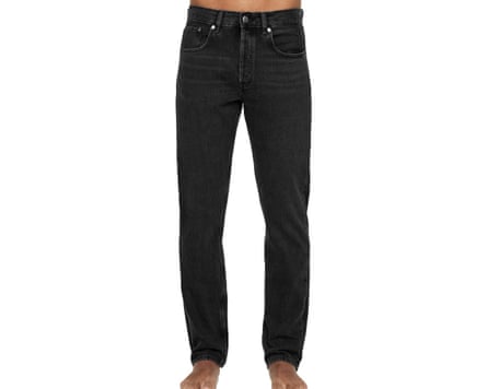 A cropped at waist image of a model wearing black Arket jeans.