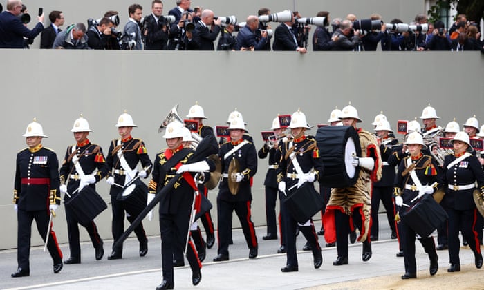 Members of a military marching band walk outside the Westminster Abbey.