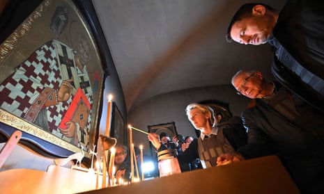European Commission president Ursula von der Leyen lights a candle in a church during a visit to a mass grave site in Bucha, Ukraine, on Friday