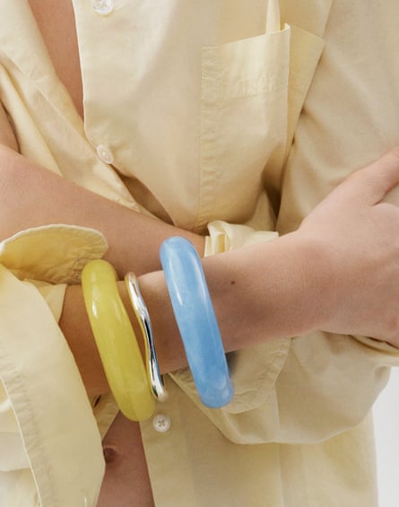 close-up of yellow, blue and silver bracelets on woman’s wrist