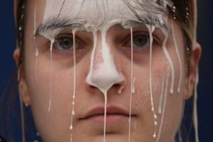 Close-up of a woman with white fluid dripping down her face