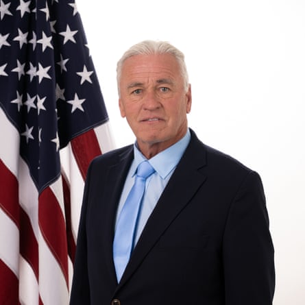 Man in suit in front of US flag.