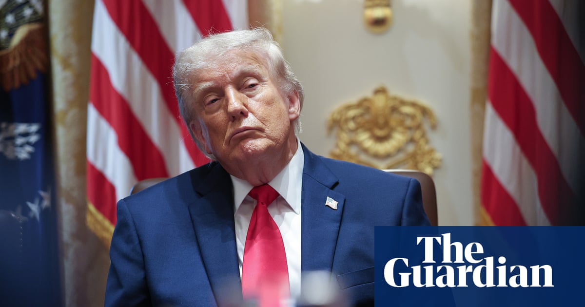 Russell Vought reviews a stack of grant applications to see which ones adequately cite the Federalist Papers, Lee Greenwood lyrics, and Donald Trump’s Truth Social feed.