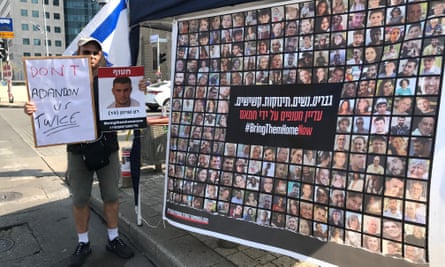 Zeev Scherman holds a placard of an abducted relative, Ron Scheerman, at a rally in Tel Aviv