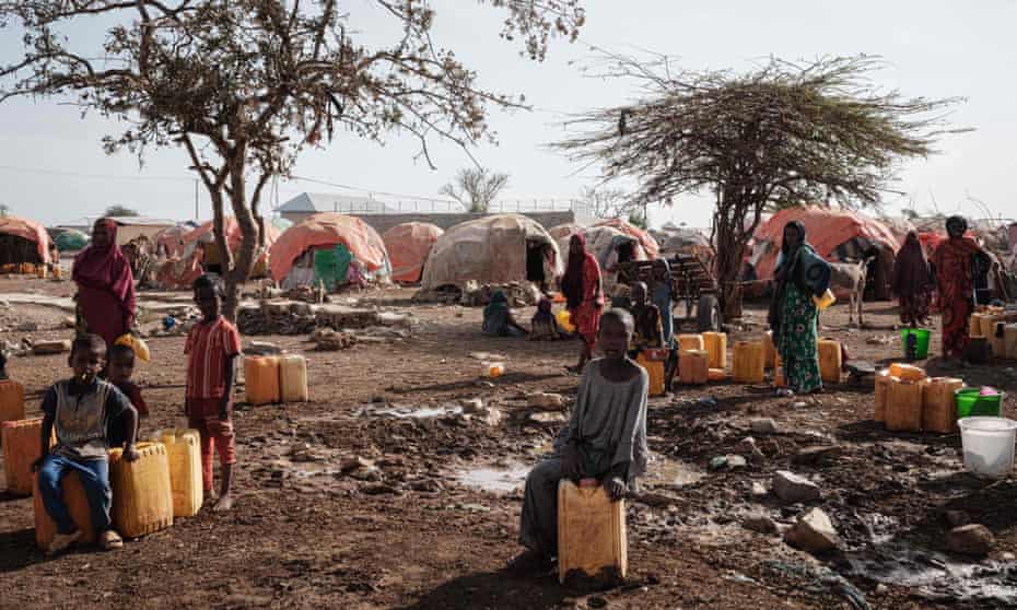 People wait for water with containers at a camp, one of the 500 camps for internally displaced persons (IDPs) in town, in Baidoa, Somalia.
