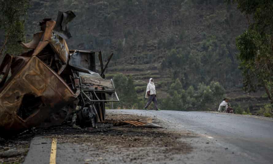 A man crosses near a destroyed truck on a road leading to the town of Abi Adi, in the Tigray region of northern Ethiopia