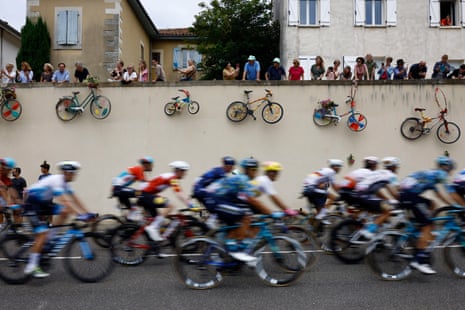 Spectators look on as the peloton passes by.