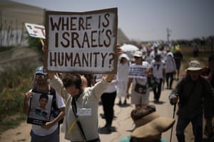 Peace activists march and hold a sign reading ‘Where is Israel’s humanity?’
