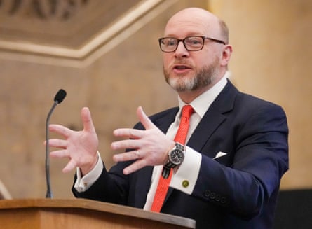 Liam Byrne speaking at a podium and gesturing with his hands