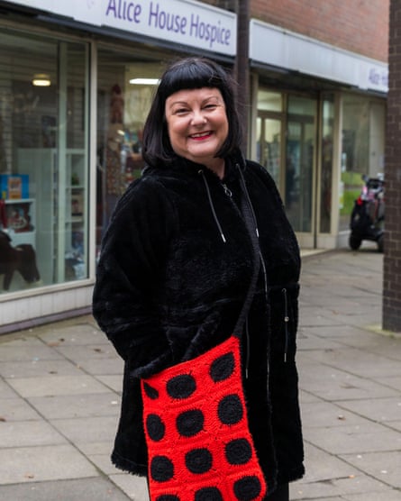 smiling woman wearing black with a red crochet bag