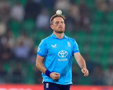 Liam Dawson, in England kit, throws a cricket ball into the air
