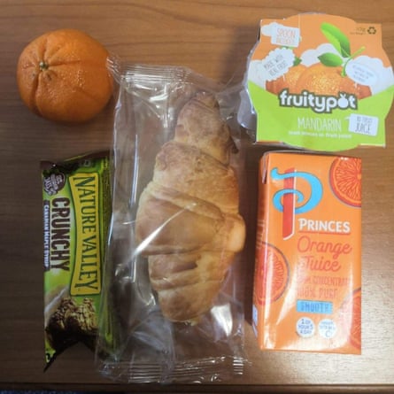 An image of a lunch pack delivered to self-isolating Edinburgh students on campus. It includes an orange; a drink; a croissant; an oat bar; and a jelly pot.