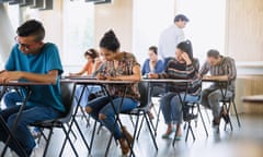 Professor watching college students taking test in classroom<br>GettyImages-683735779