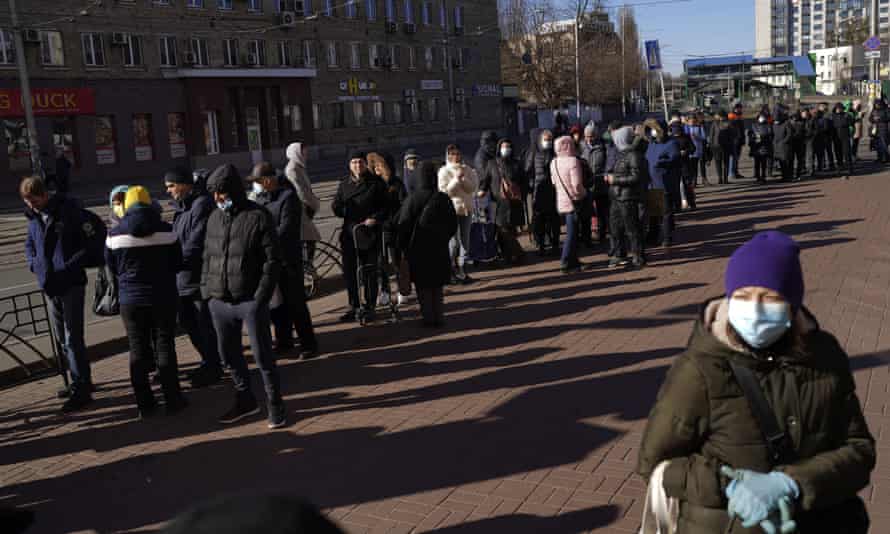 People wait in a queue outside a supermarket in central Kyiv, Ukraine.