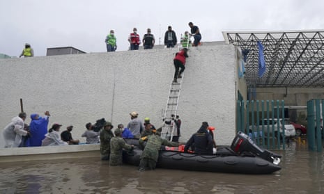 Soldiers rescue health workers trapped on the roof of the flooded hospital in Tula in Hidalgo state, Mexico. 