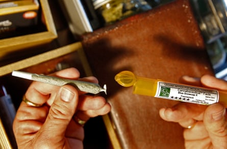 close-up of a hand holding a rolled marijuana cigarette