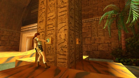 Lara Croft stands inside an archaeological ruin.