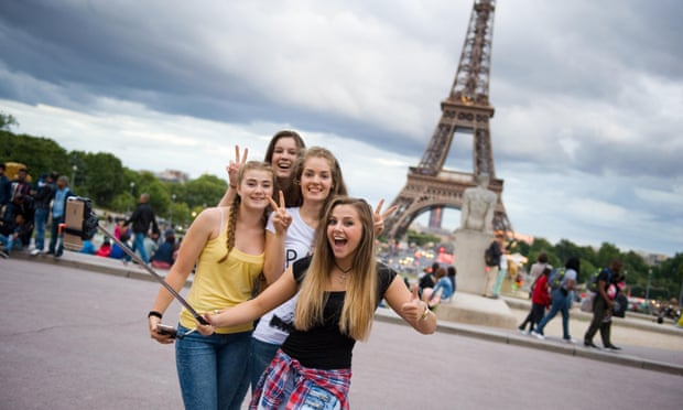 Girls with selfie stick in front of the Eiffel Tower in Paris