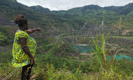 A pregnant woman oints to the site of the Panguna mine in Bougainville