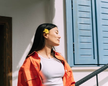 A beautiful young Asian woman walking in the old bright city. Flower in a hair in springtime.