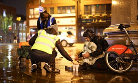 Volunteers in London step in to give food to a homeless man, last November