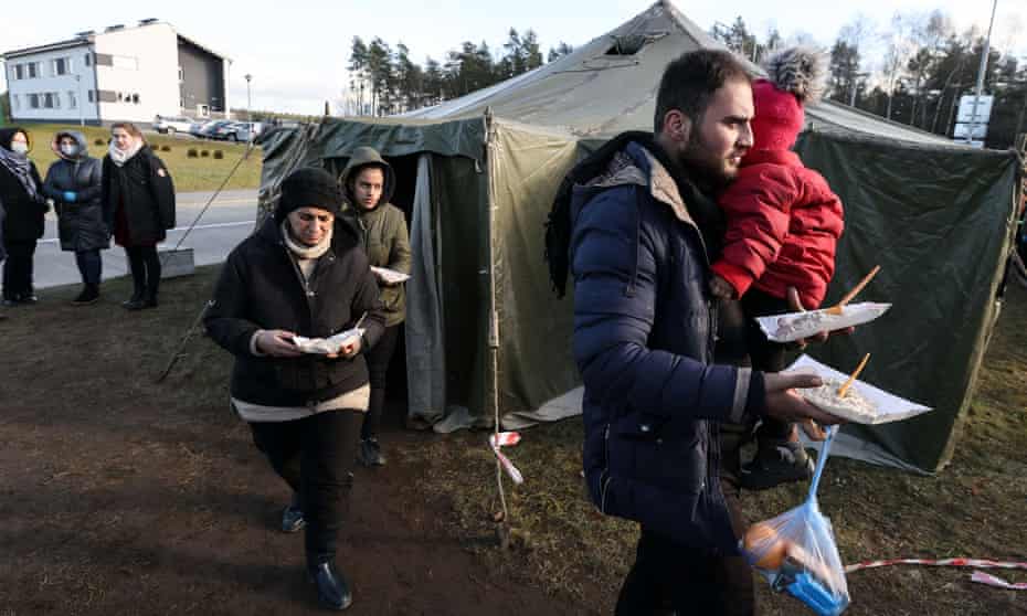 People receive food at the transport and logistics centre near the Bruzgi border point on the Belarusian-Polish border in the Grodno region