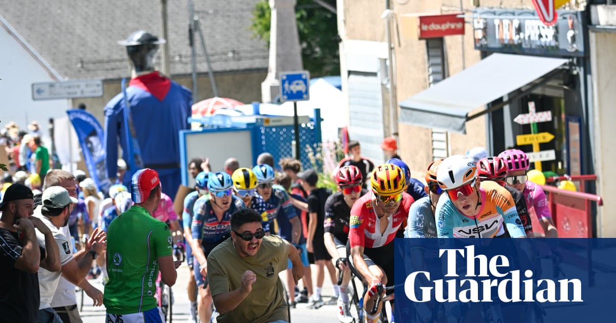 Một người hâm mộ phấn khích chạy bên cạnh tay đua của NSN Cycling Team khi đoàn đua đi qua một thị trấn trong chặng 18 từ Voiron đến Orcieres-Merlette. (Ảnh: Photograph: Pete Goding/Goding Images)