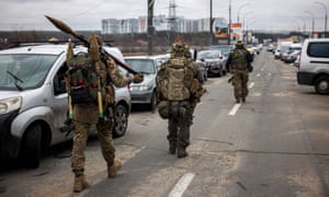 I militari ucraini portano granate a razzo e fucili di precisione mentre camminano verso la città di Irpin, a nord-ovest di Kiev.