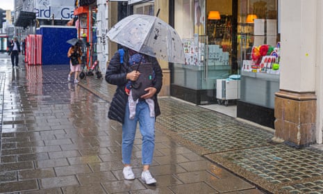 Pedestrians and shoppers on London's Oxford Street are caught in a rain shower