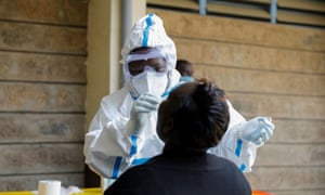 A health worker takes a swab from a woman during mass testing in Nairobi, Kenya.