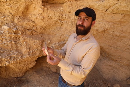 Mohammed al-Fares holds pottery broken by looters in a dug-out burial site on the outskirts of the ancient city of Palmyra.