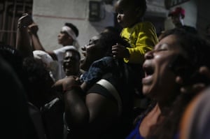 Residents chants during an overnight Catholic procession of the statue of San Juan Bautista, marking the start of a month-long celebration of the Saint in the neighbourhood of San Agustin in Caracas
