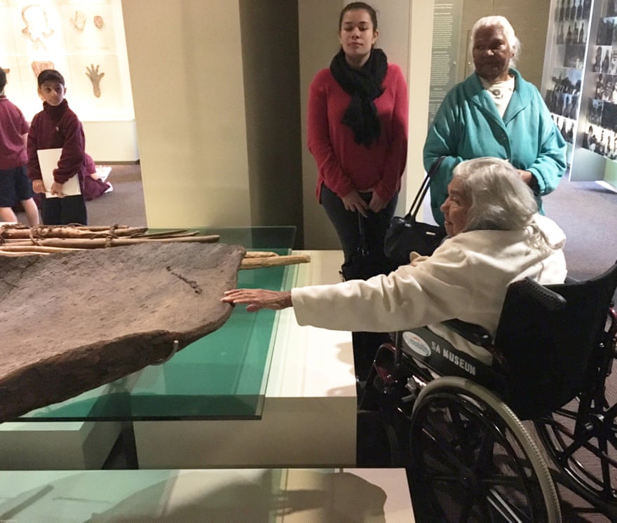 A Barkindji elder touches a bark canoe