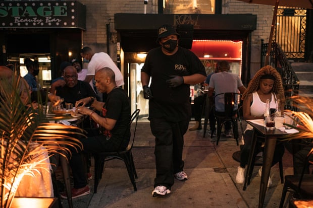 An employee at The Row Harlem walks through the outdoor dining sections during Friday evening dinner service.